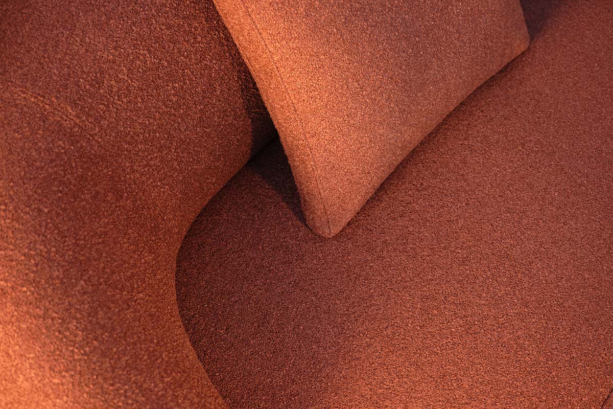 Close-up of Zenith Fabric in Russet, highlighting its warm rust tone and soft, textured weave across upholstered cushions.